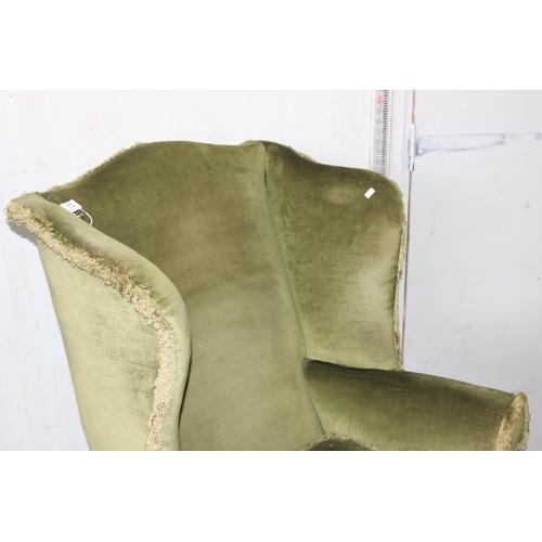 13 - A vintage green upholstered wingback armchair, Georgian style