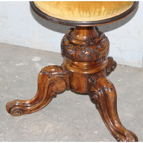 18 - A 19th century adjustable topped piano stool with gold coloured upholstery and carved details