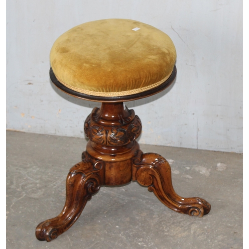 18 - A 19th century adjustable topped piano stool with gold coloured upholstery and carved details