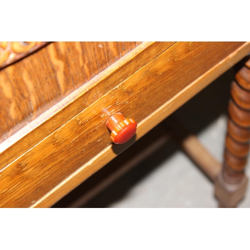 3 - An Art Deco period oak sewing box on barleytwist legs with Bakelite handle