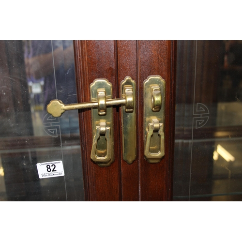 82 - A large antique style 4 door display cabinet with mirrored back and interesting brass furniture