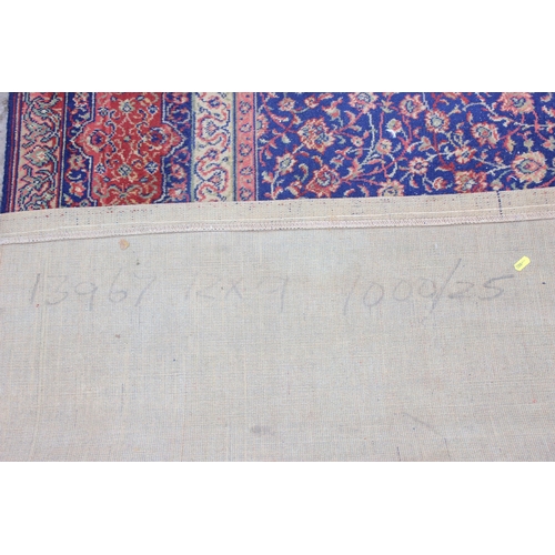 205 - A large decorative blue ground rug, approx 365cm x 275cm