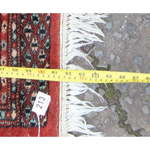 213 - Hand tied Pakistani Bokhara red ground rug with 22 gul central panel