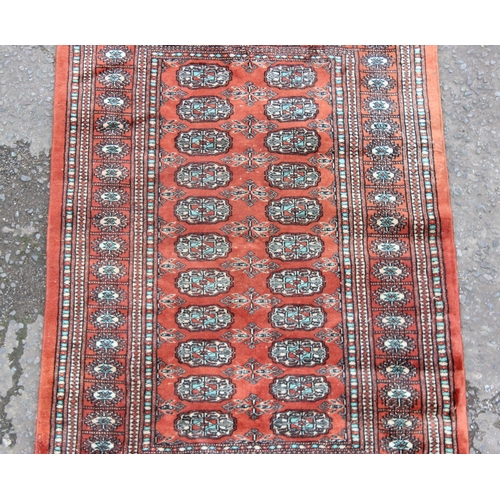 214 - Hand tied Pakistani Bokhara red ground rug with 22 gul central panel