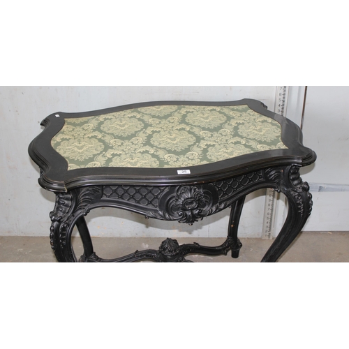 25 - A 19th century Continental ebonised and profusely carved side table with green fabric top in the Ger... 