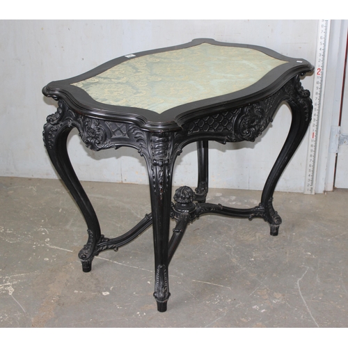 25 - A 19th century Continental ebonised and profusely carved side table with green fabric top in the Ger... 