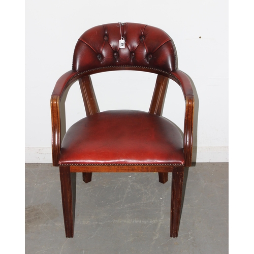 49 - An ox-blood red button backed armchair or desk chair with metal studded decoration