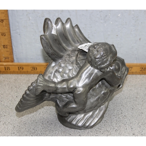 1727 - Solid tin model of a merboy playing with a fish