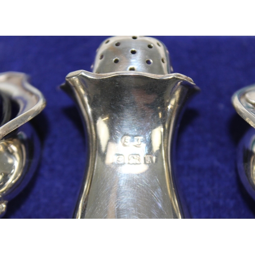 1026 - A boxed silver cruet set, Birmingham 1925/6 by William Suckling and 2 associated silver spoons, appr... 