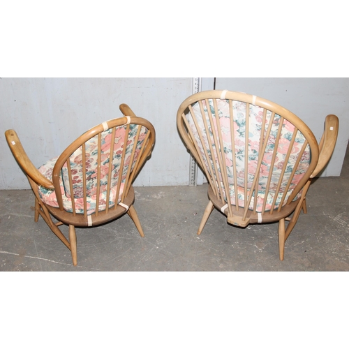 130 - Pair of blonde Ercol low easy lounge chairs with floral cushions, blue & gold labels