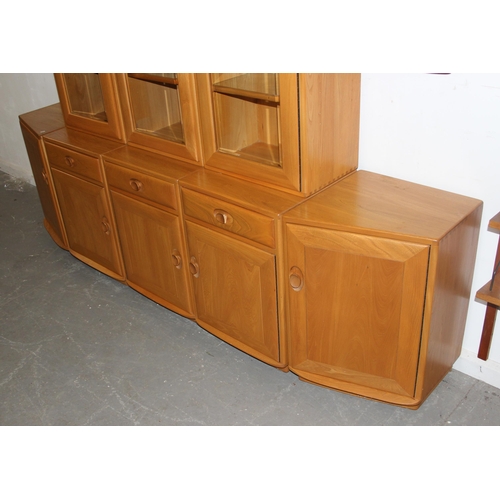 134 - A large blonde Ercol modular type wall unit comprising of shelves around 3 glazed display cabinets, ... 