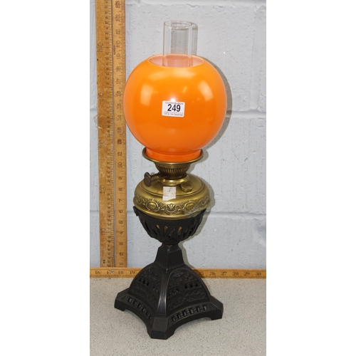 249 - An antique Art Nouveau designed table lamp with cast iron base, brass reservoir and orange glass sha... 