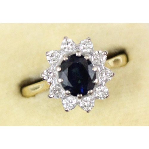 1114 - An 18ct gold ring set with large central blue sapphire surrounded by 10 diamonds, marked for London ... 