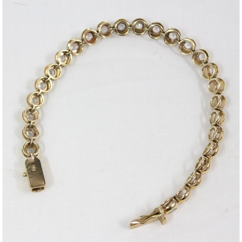 1133 - A 14ct gold mounted tennis bracelet set with 28 cut white stones (believed to be diamonds) in bubble... 