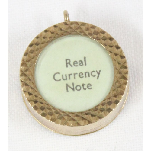 1141 - 9ct gold charm containing a folded £1 note, approx 3.32g gross