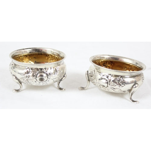 1083 - A pair of silver salts with embossed floral decoration, Birmingham 1904, makers mark rubbed, approx ... 