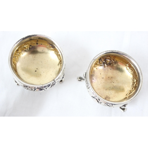 1083 - A pair of silver salts with embossed floral decoration, Birmingham 1904, makers mark rubbed, approx ... 