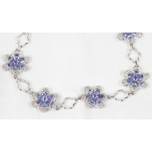 1158 - An 18ct white gold bracelet set with 6 flowers made from diamonds and cornflower blue stones, possib... 