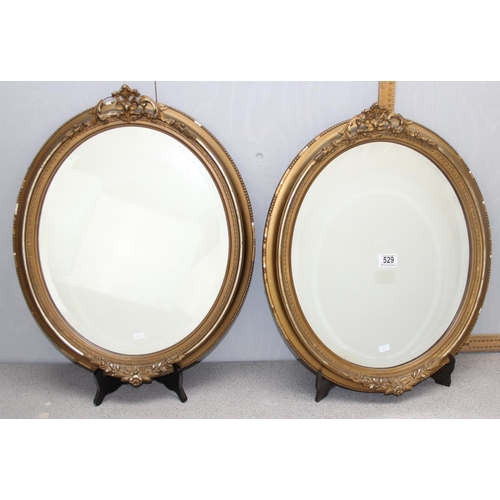 529 - A pair of vintage oval gilt framed mirror with rococo style details