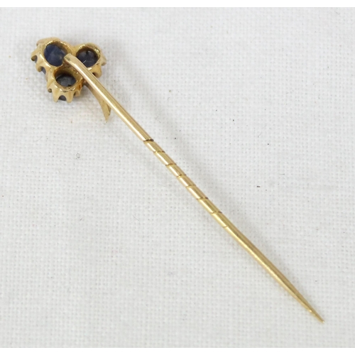 1199I - An antique 15ct gold stick pin formed as a 3 leaf shamrock from blue stones, possibly sapphires, unm... 