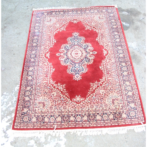 208 - A large decorative red ground rug with central medallion, approx 240cm x 173cm