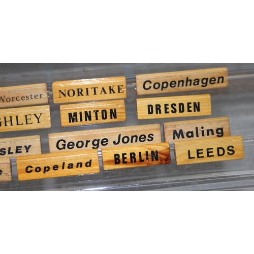 1650B - A large qty of wooden display name plaques naming famous ceramics factories, ideal for antique centr... 