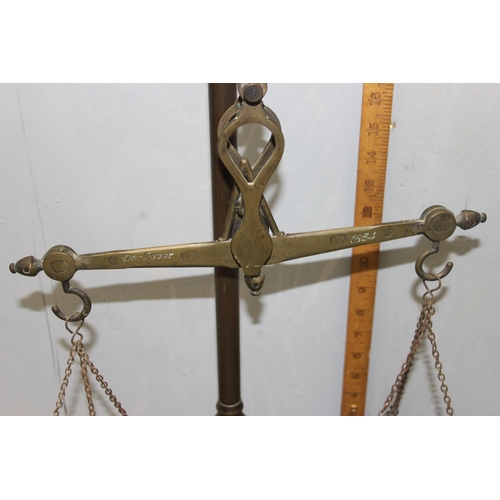 747 - A set of antique brass balance beam apothecary scales with weights inset into base, cross beam marke... 