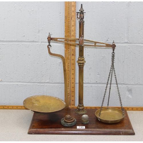 703 - A set of antique brass balance scales by Avery, with weights, on wooden base