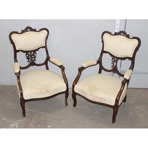 11 - A pair of Victorian armchairs with carved details and stuffed seats and backs