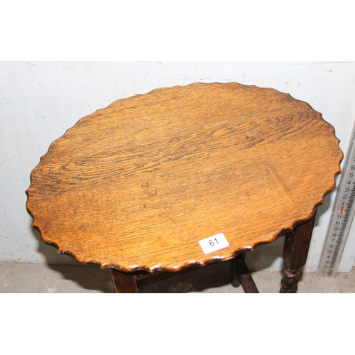 61 - A small vintage oak table with piecrust edge and barleytwist supports, approx 55cm wide