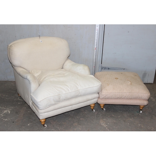 100 - In the style of Howard & Sons, low seated cream sofa chair with associated foot stool, purchased by ... 