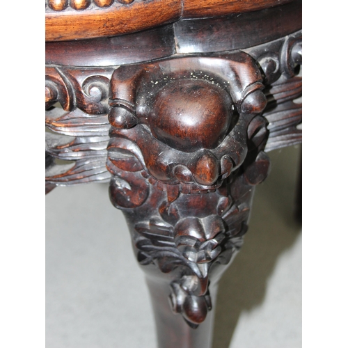 106 - A Chinese carved hardwood jardinière stand with red marble inset top, the legs profusely carved with... 