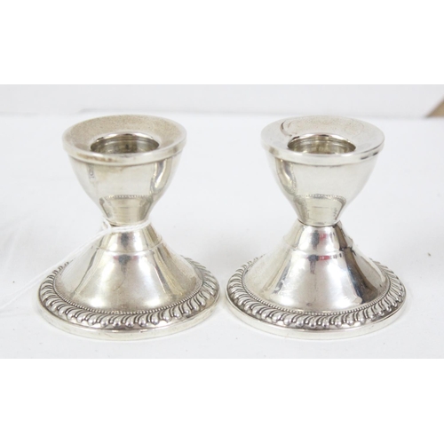 1042 - A pair of sterling silver dwarf candlesticks, weighted, likely American, approx 6cm tall