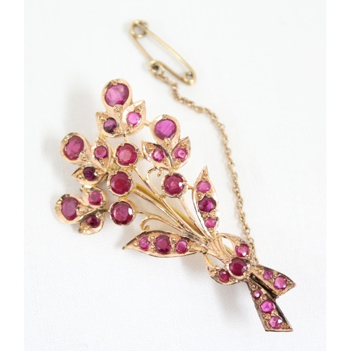 1116 - An antique 14ct gold and ruby set brooch formed as a floral spray, the largest ruby approx 5mm in di... 