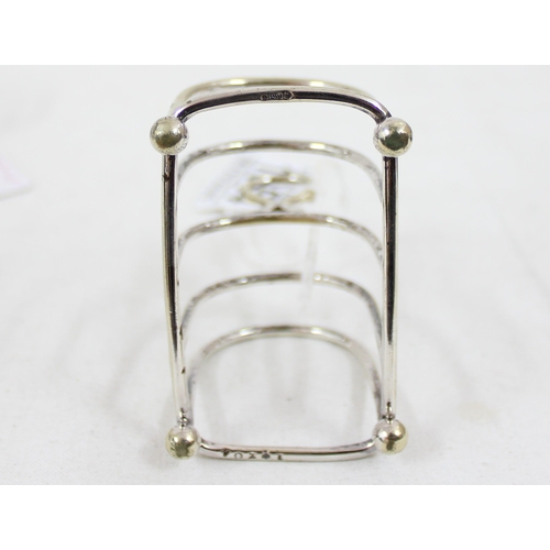 1054 - A small silver toast rack, London 1933, a silver egg cup Sheffield 1914 & a small silver plated toas... 