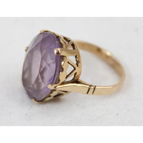 1157 - An 18ct yellow gold ring mounted with a large cut purple stone, unmarked but XRF tested as 18ct gold... 