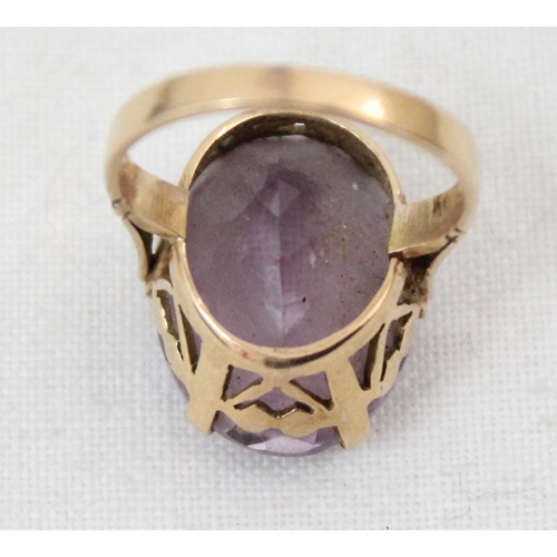 1157 - An 18ct yellow gold ring mounted with a large cut purple stone, unmarked but XRF tested as 18ct gold... 