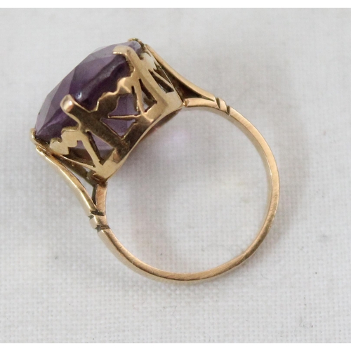 1157 - An 18ct yellow gold ring mounted with a large cut purple stone, unmarked but XRF tested as 18ct gold... 