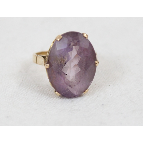 1157 - An 18ct yellow gold ring mounted with a large cut purple stone, unmarked but XRF tested as 18ct gold... 