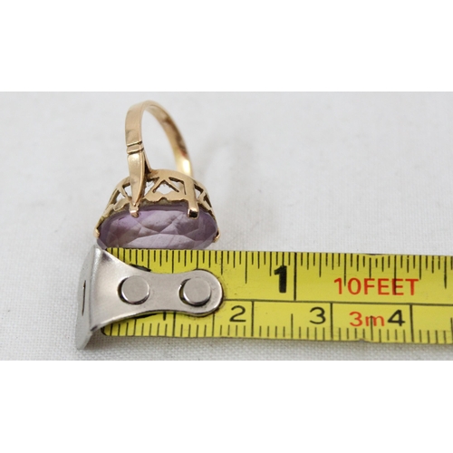 1157 - An 18ct yellow gold ring mounted with a large cut purple stone, unmarked but XRF tested as 18ct gold... 