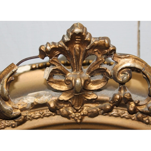 460 - A pair of vintage oval gilt framed wall mirrors with rococo style details, approx 57cm tall