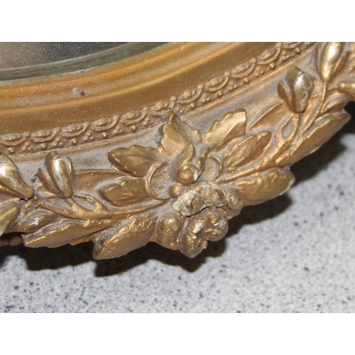 460 - A pair of vintage oval gilt framed wall mirrors with rococo style details, approx 57cm tall