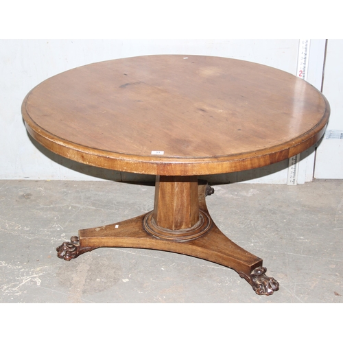 65 - A 19th century mahogany tilt topped breakfast table with pedestal base and carved lion paw feet, app... 