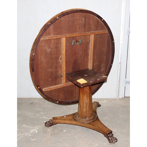 65 - A 19th century mahogany tilt topped breakfast table with pedestal base and carved lion paw feet, app... 