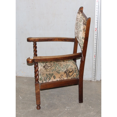 44 - An Art Deco period oak framed low armchair with barleytwist supports