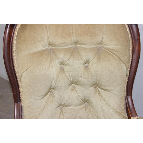 64 - A 19th century button backed low armchair with mahogany frame and brass castors