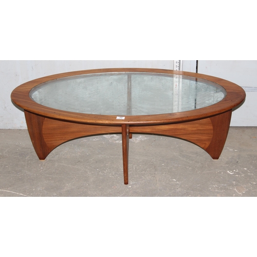 77 - Mid-century G-Plan teak Astro oval coffee table with glass top, raised on curved supports, 42cm high... 