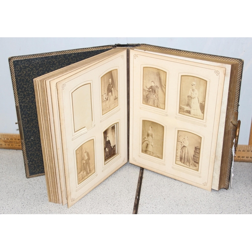 500 - 2 Victorian leather bound photograph albums with musical movements, also containing some photographs