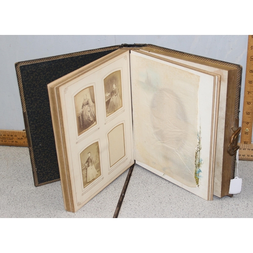 500 - 2 Victorian leather bound photograph albums with musical movements, also containing some photographs