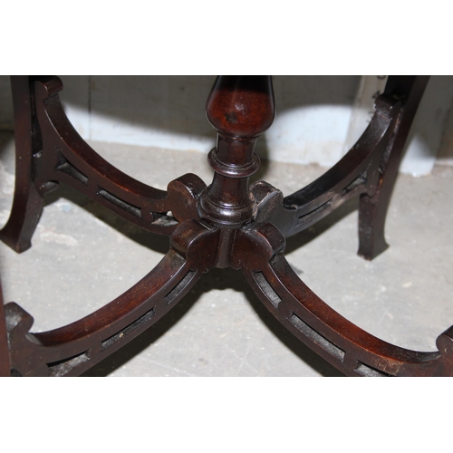 86 - An antique style mahogany revolving bookcase table with fretwork panels